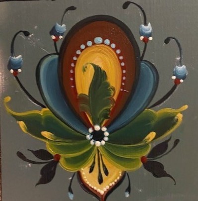 Folk flower motif in green, gold, and blue painted on a gray ground