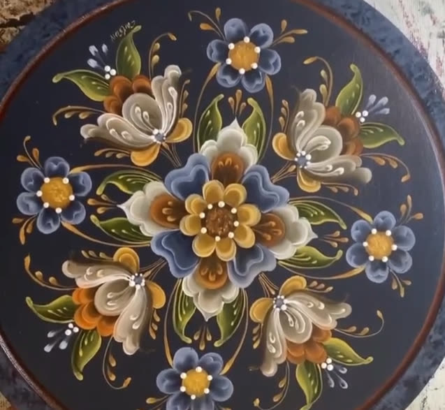 Navy platter filled with a full bouquet of blue, cream, and gold rosemaling flowers