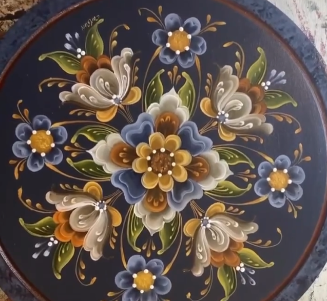 Navy platter filled with a full bouquet of blue, cream, and gold rosemaling flowers