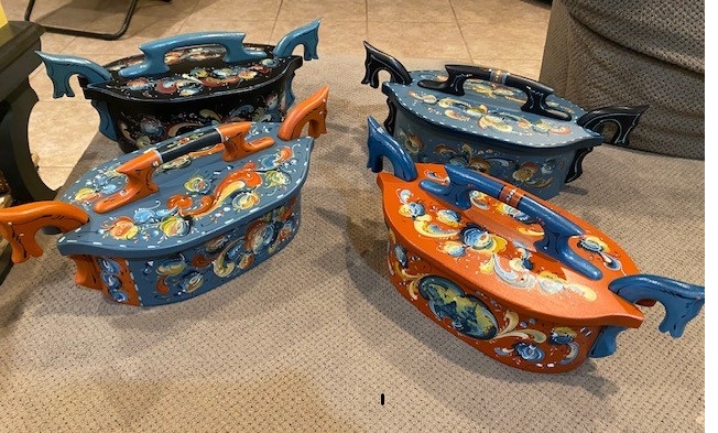 Four hand-painted tine boxes with horse-head handles in orange, blue, and black